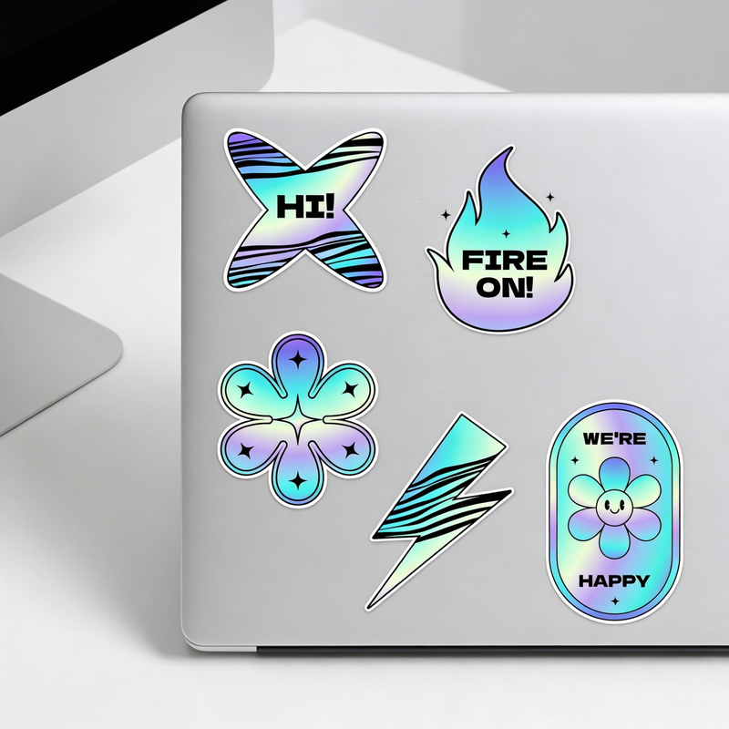 Holographic stickers on a laptop with text and designs.